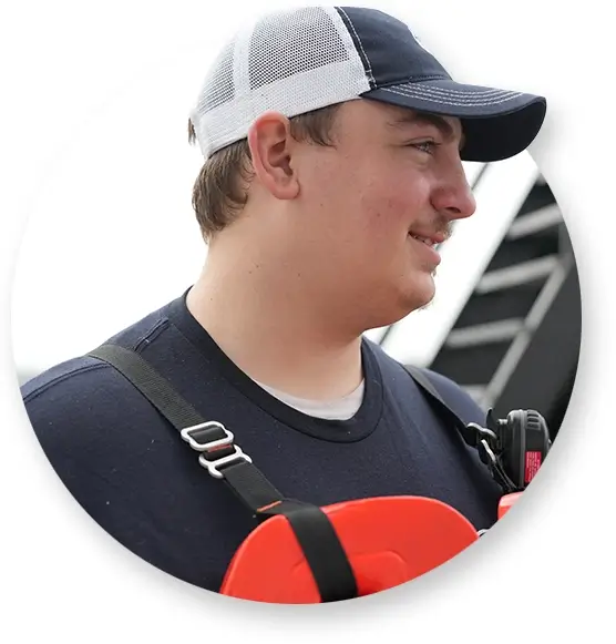 A deckhand smiling while wearing a life jacket