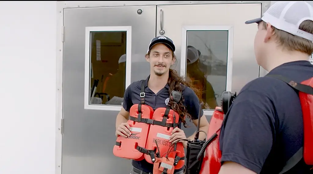 Southern Devall crewmen visiting on the deck of a ship while wearing life jackets