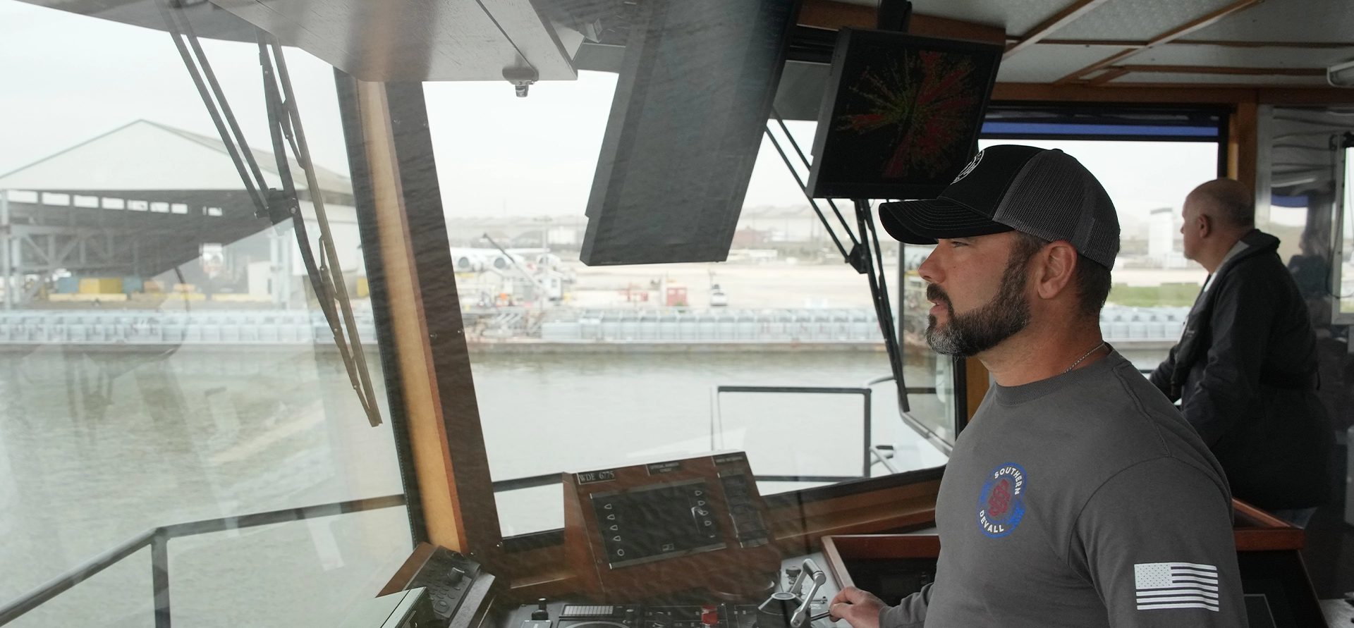 A Southern Devall Crewman looking out the window at the helm of a barge