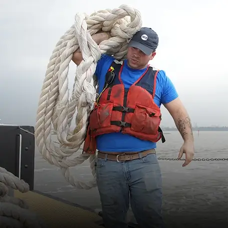 A Southern Devall crewman hoisting up large rope