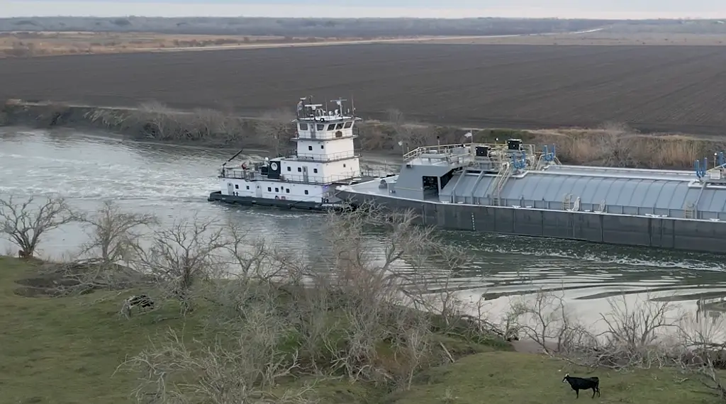 A towboat pushing a large barge through a river