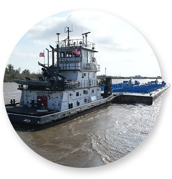 A Southern Devall barge moving material down a river in the afternoon