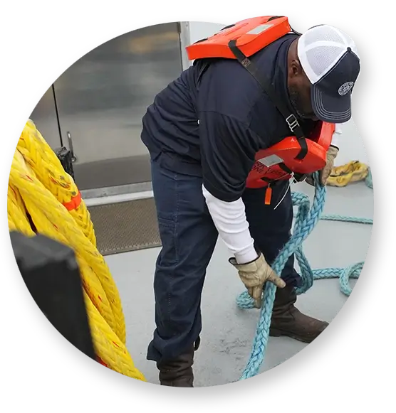 A Southern Devall crewman pulling up blue rope