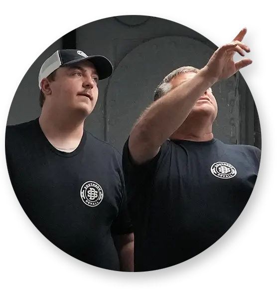 Two Southern Devall employees in black shirts looking up at something off camera