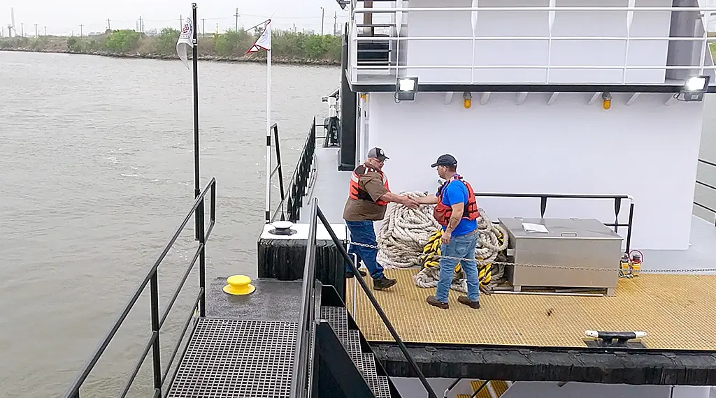Two Southern Devall deckhands shaking hands on the deck of a barge