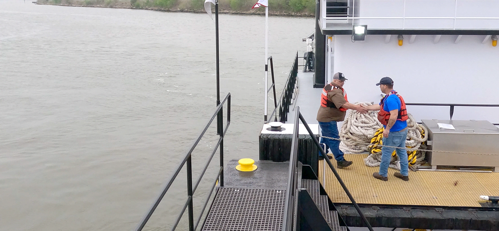 Two Southern Devall deckhands shaking hands on the deck of a barge