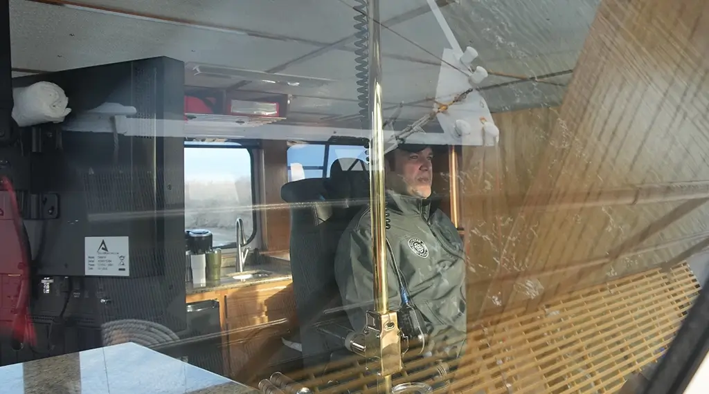 Looking in on a captain inside the cockpit of a barge