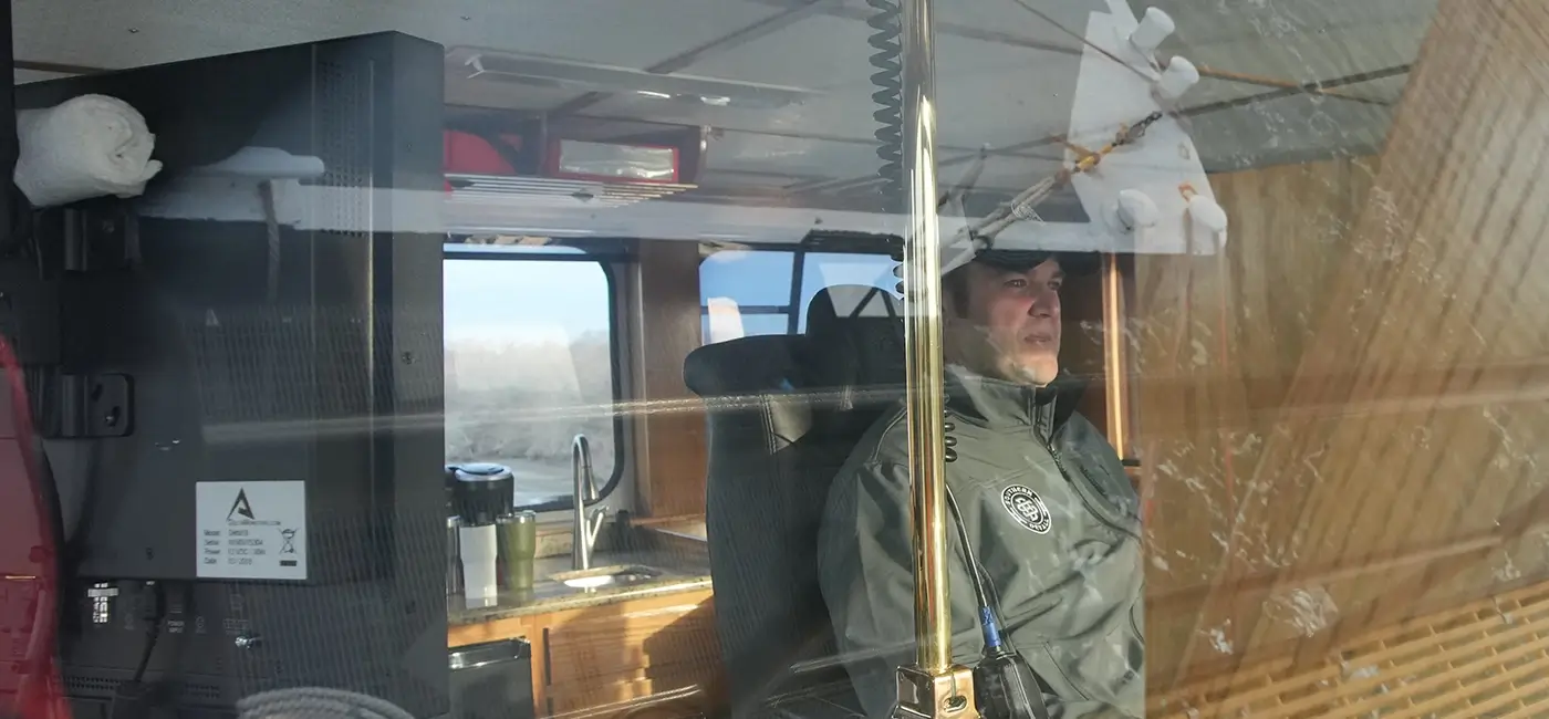 Looking in on a captain inside the cockpit of a barge